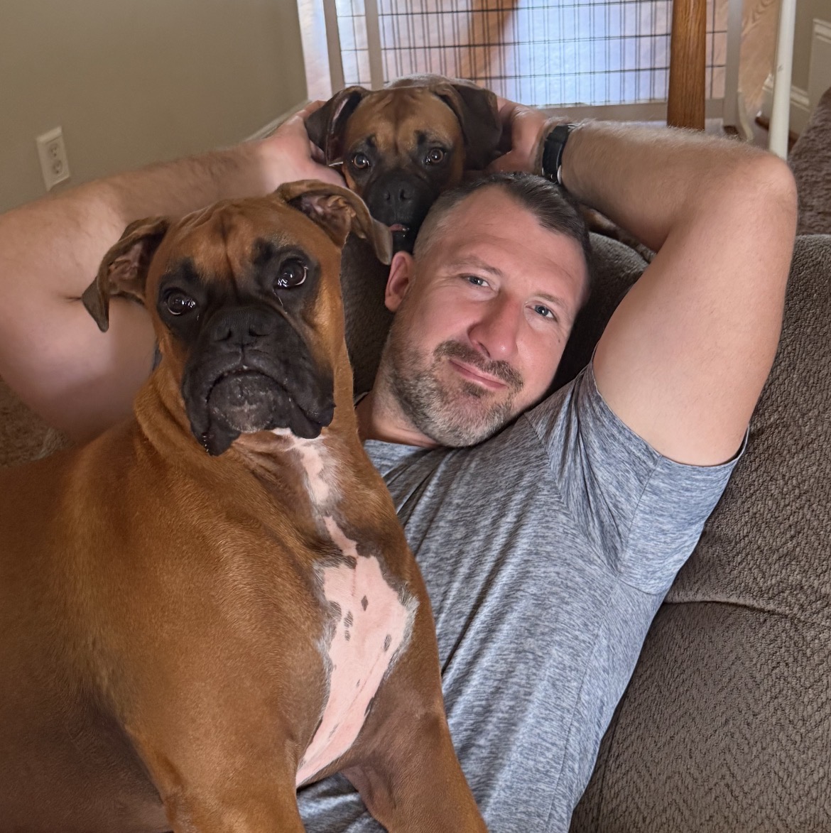 Danny Richard relaxing at home with his two boxer dogs